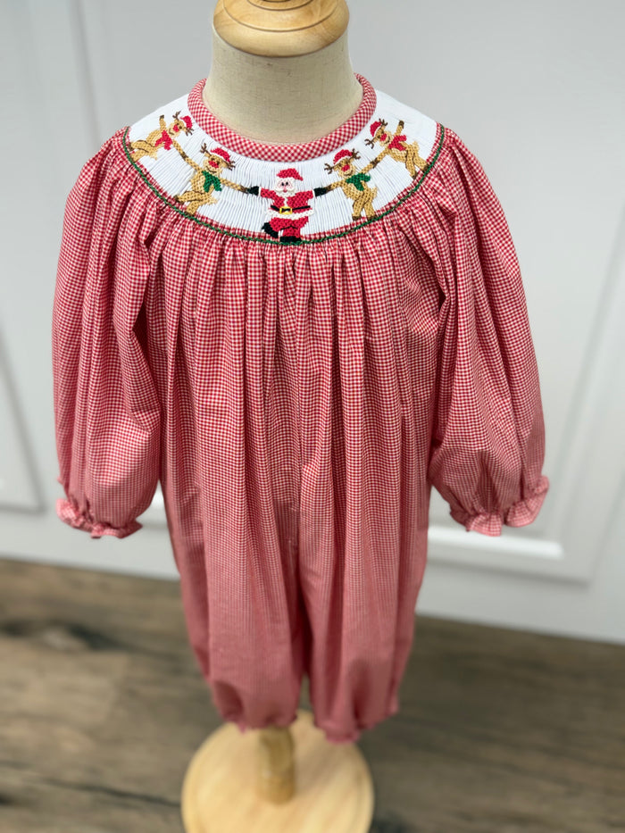 Dress your little one in festive charm with the Girls Rockin' Reindeer Long Bubble from Cape Point Clothing Co. This vibrant red and white gingham outfit features a smocked neckline adorned with playful dancing reindeer and Santa motifs, perfectly capturing holiday joy. The long bubble style offers a comfortable yet stylish fit, making it ideal for holiday gatherings or special occasions. Celebrate the season in a look that’s both adorable and timeless.