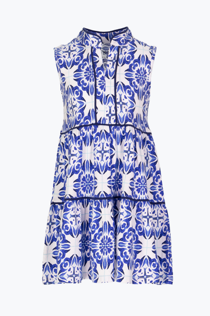 Embrace the beauty of summer in our Girls Amalfi Tiles Robin Dress by Duffield Lane! This 100% cotton dress is adorned with a classic blue and white Amalfi Tile pattern, giving it a timeless and elegant look. The tiered skirt and v-neck provide both style and comfort, making it the perfect addition to any girl's wardrobe.